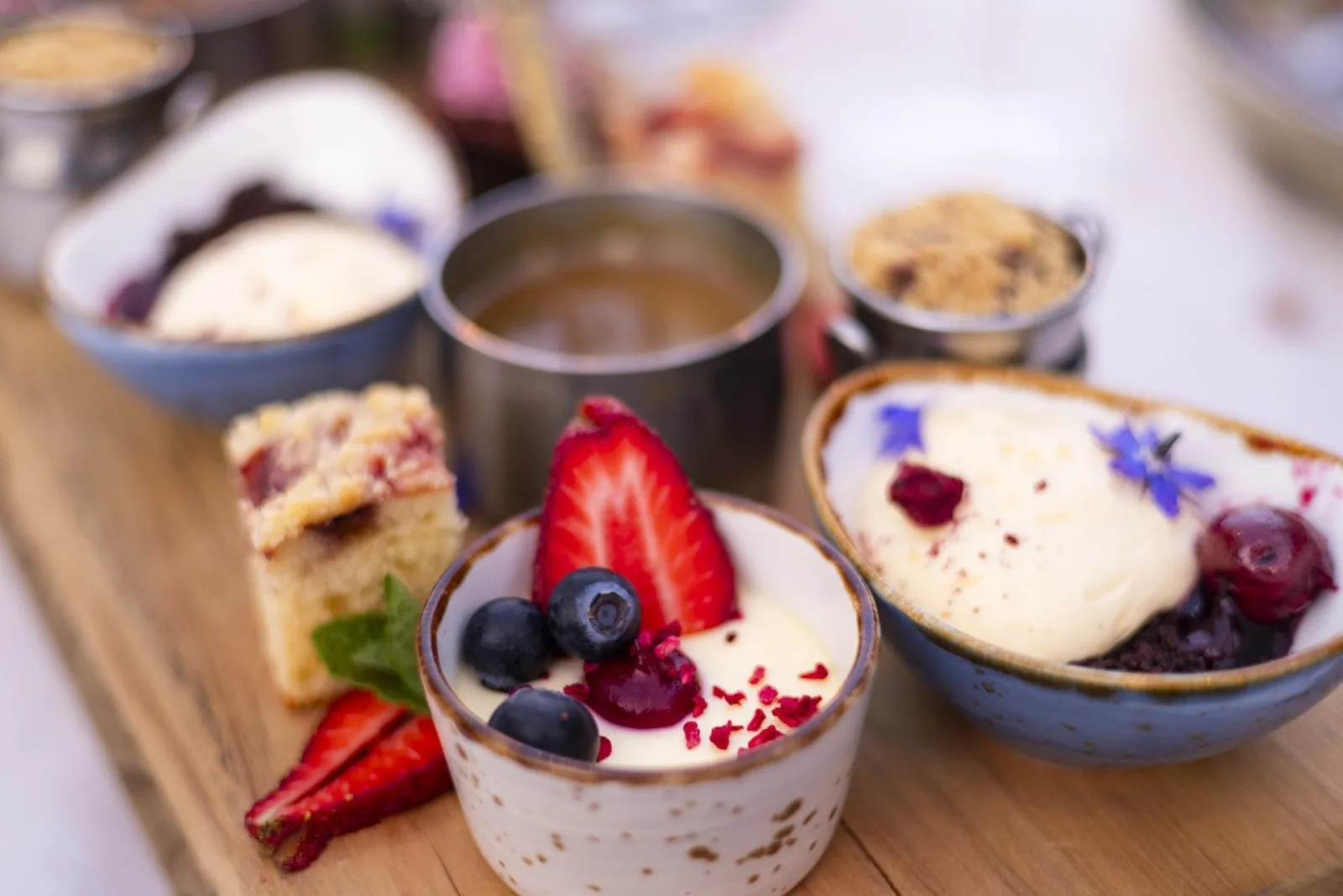 The dessert table at the Colonel's Homestead — panna cotta, berries, cakes and preserves in small bowls