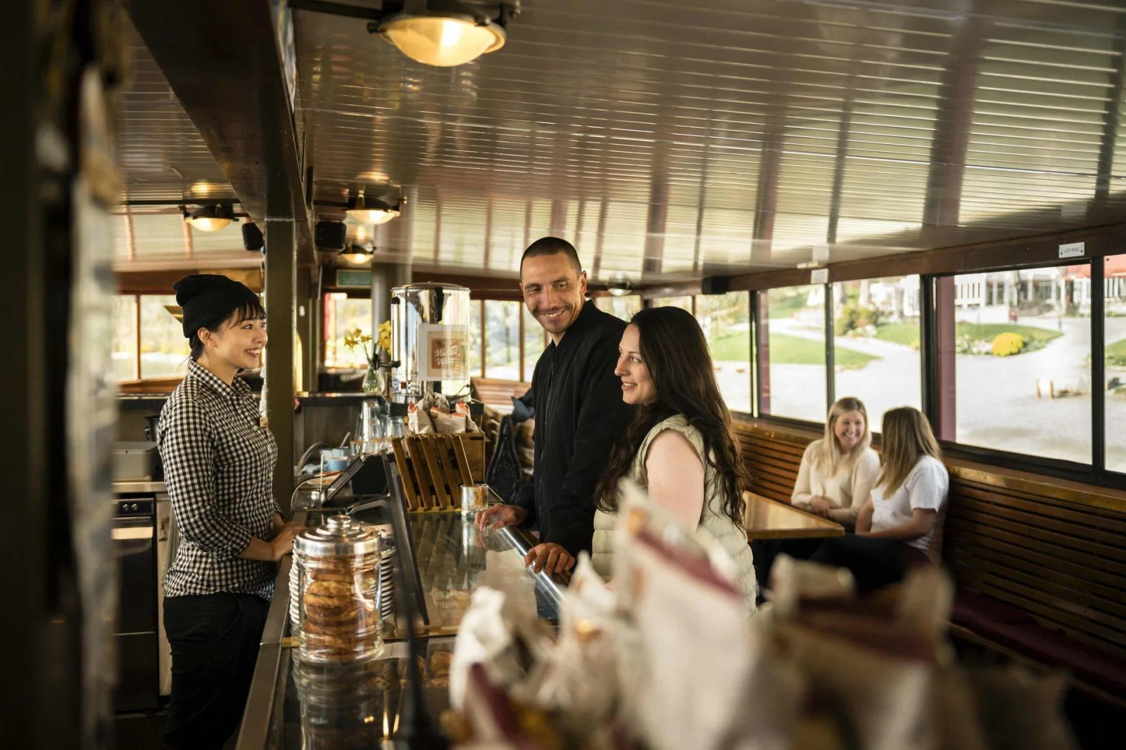 Passengers at the bar in the wood-panelled lower saloon of the TSS Earnslaw