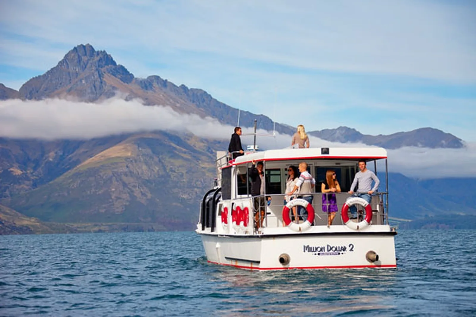 The Million Dollar Cruise vessel on the lake with cloud lying along the mountains behind