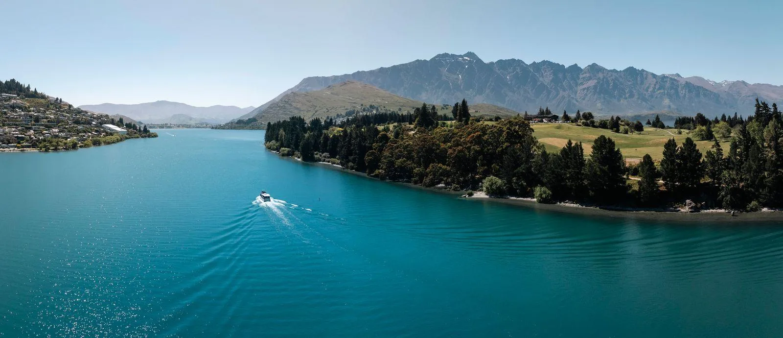 The turquoise Frankton Arm of Lake Whakatipu with the Kelvin Heights peninsula and a boat wake