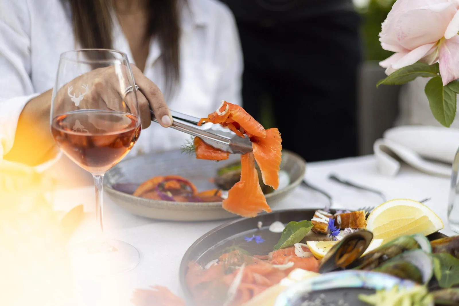A guest serving smoked salmon onto a plate of seafood and mussels at the Walter Peak buffet